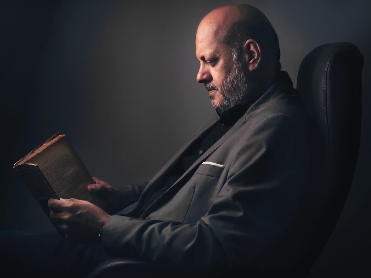 Raimundo Jùnior lendo em uma poltrona
